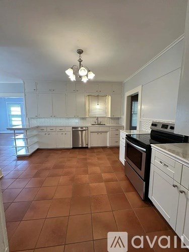 A kitchen with brown tiles and white cabinets is available for rent.