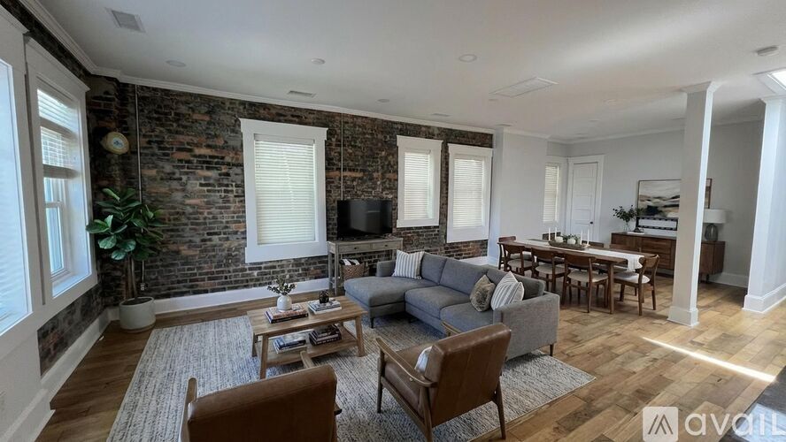 A room with wooden flooring and brick walls.