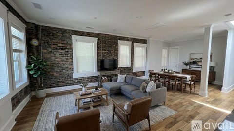 A room with wooden flooring and brick walls.