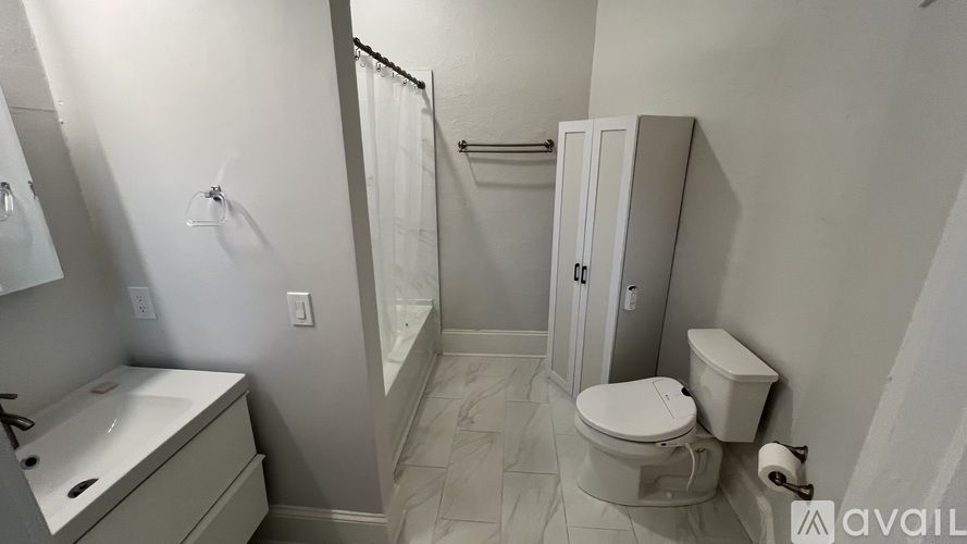 A bathroom with a toilet, sink, and shower.