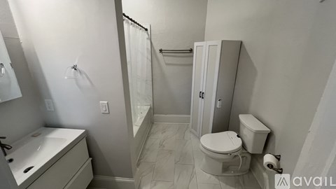 A bathroom with a toilet, sink, and shower.