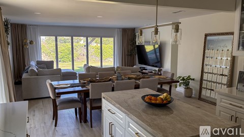 A modern kitchen and living room with a dining table and chairs.