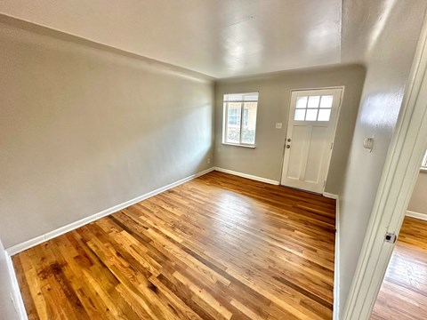 A room with carpeted floor and two windows.