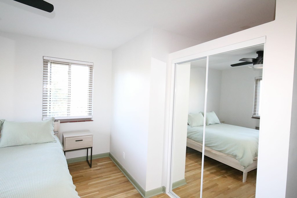 A bedroom with a bed, nightstand, and window.