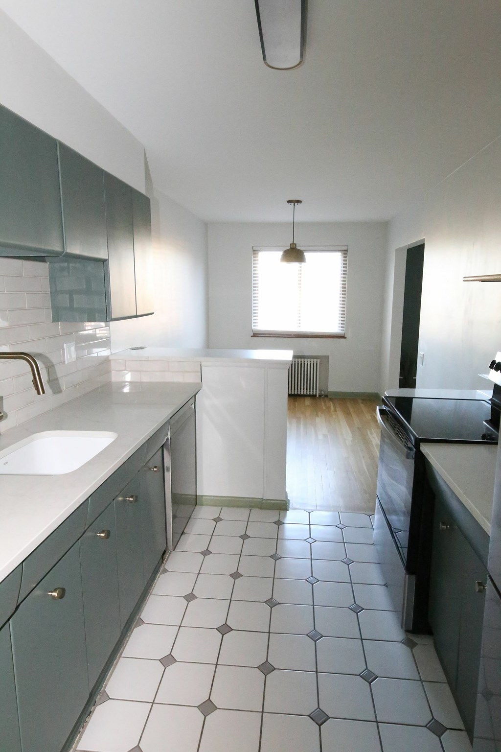 A kitchen with white and black tiles.