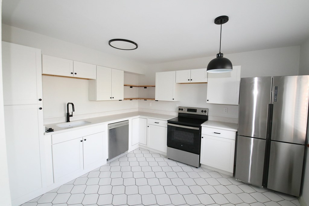 A kitchen with white cabinets and a black stove top oven.