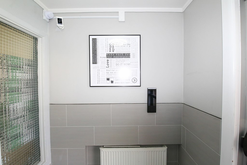 A bathroom with a poster on the wall and a radiator below it.