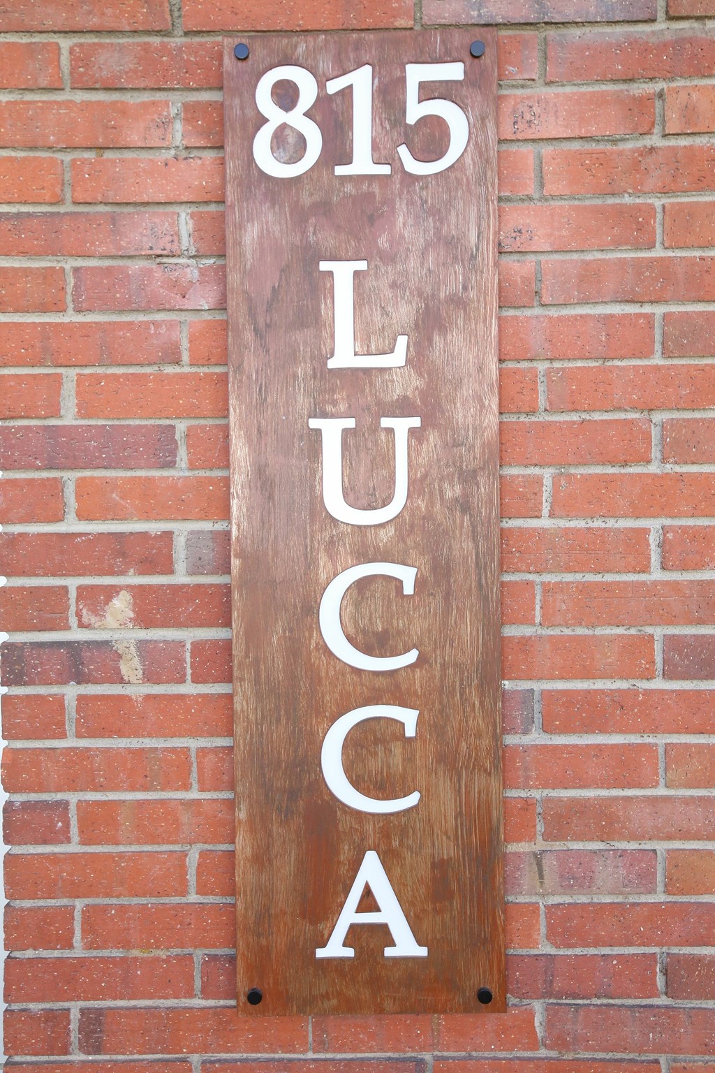 A white wall with a vent and a pipe.