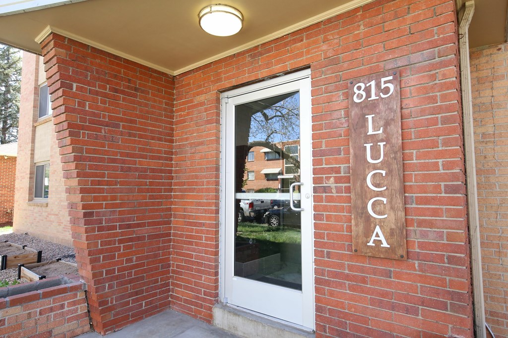 A brick building with a door and a sign that says 815 Lucca.