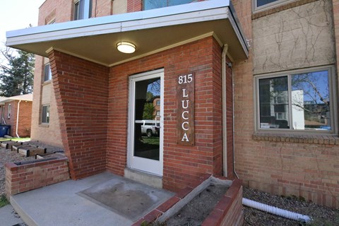A brick building with a door and a sign that says 815 Lucca.