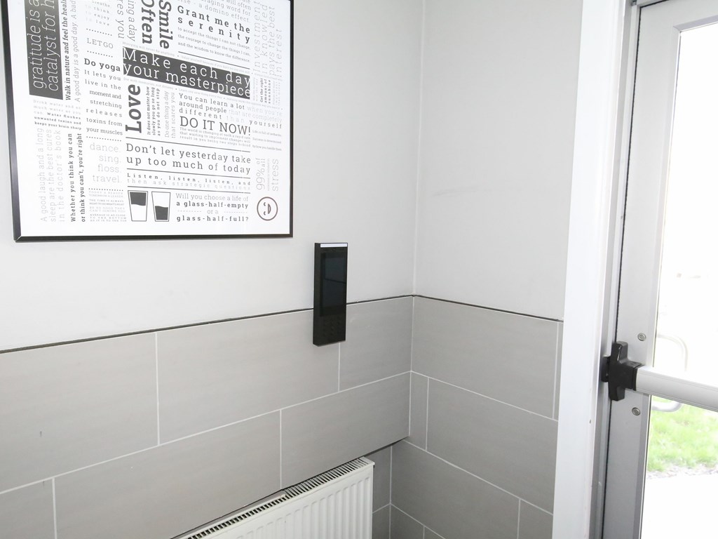 A poster with inspirational quotes is hanging on a wall next to a radiator.