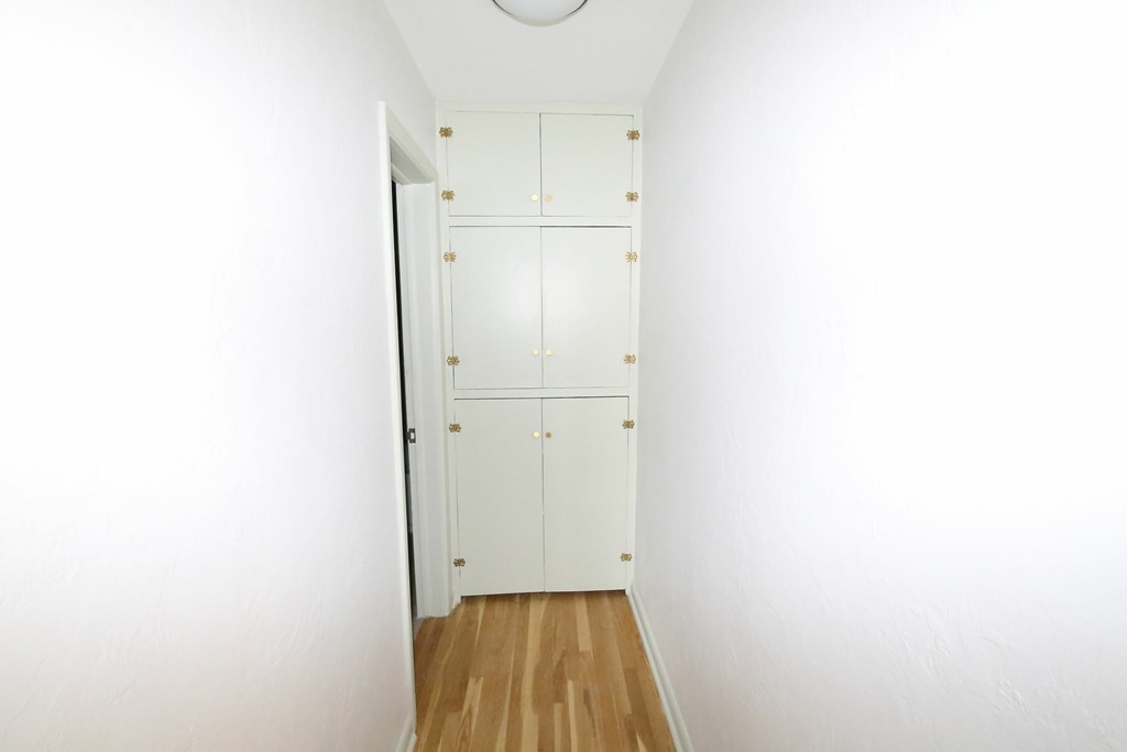 A white door with gold knobs is in a hallway.
