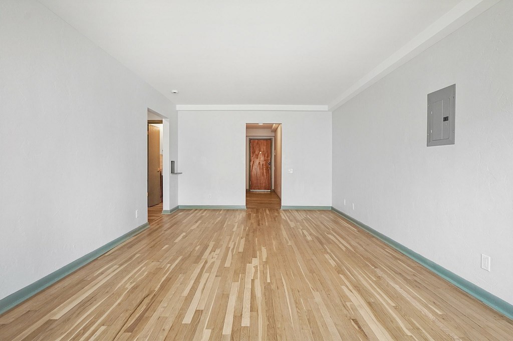 A room with a wooden floor and a door in the middle.