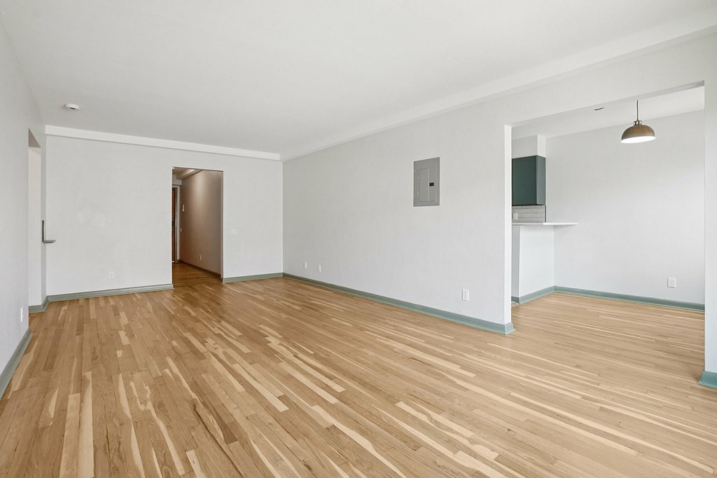 A room with wooden flooring and a white door.
