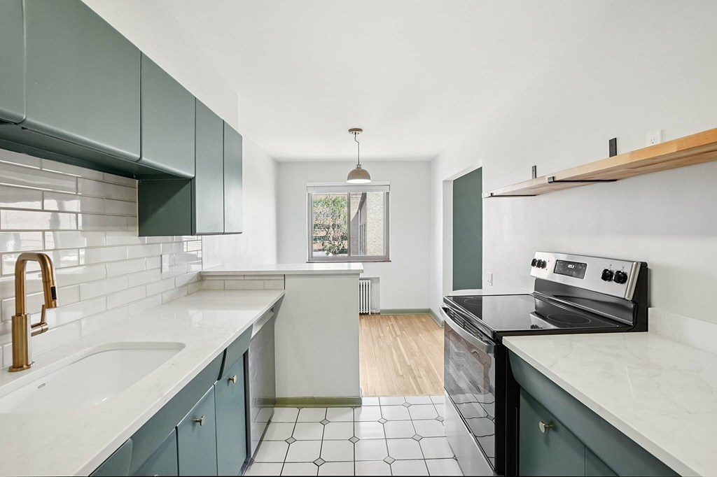 A kitchen with a black stove top oven and a white sink.