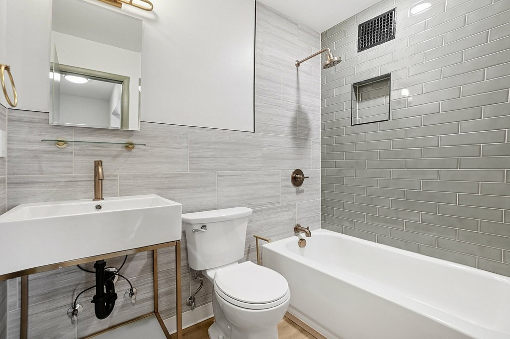 A white toilet sits next to a sink in a bathroom.