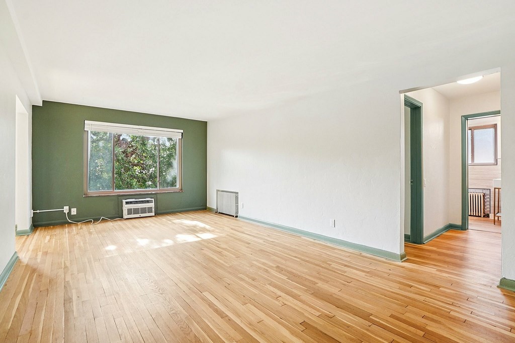 A room with a green wall and a window.