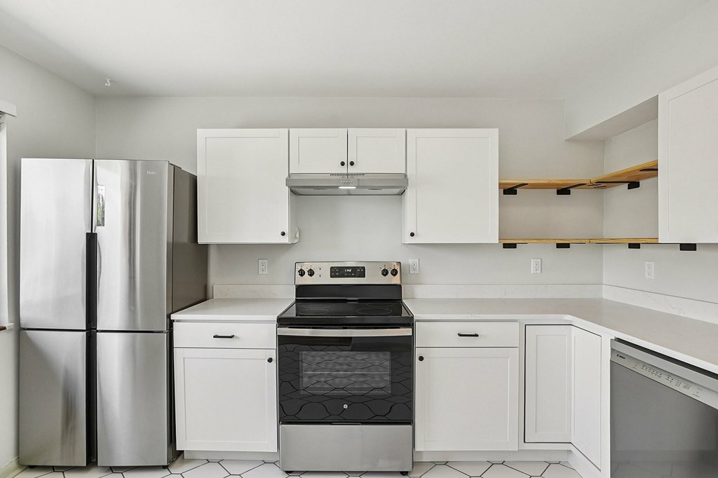 A kitchen with white appliances and cabinets.
