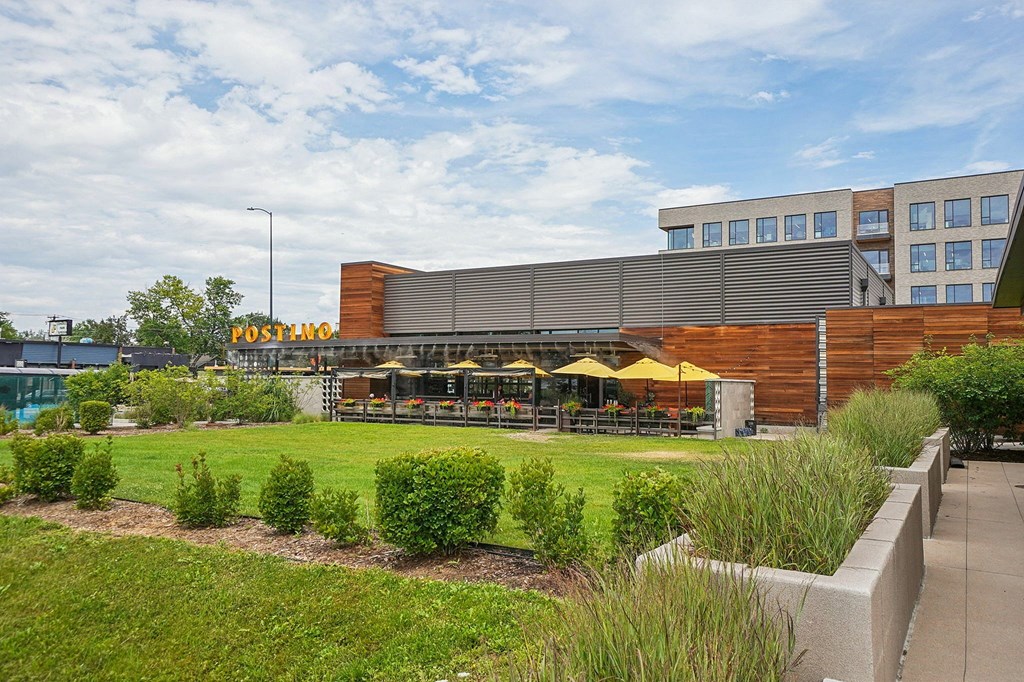 A Posthop store is located in a building with a large grassy area in front.