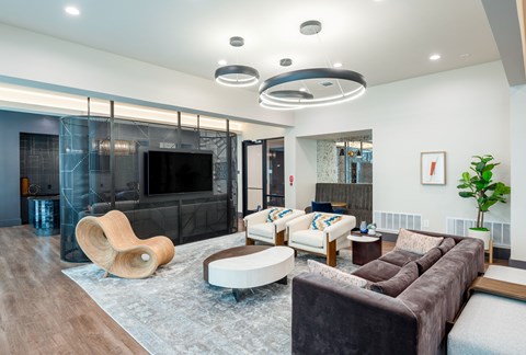 A modern living room with a brown sofa and a wooden chair.