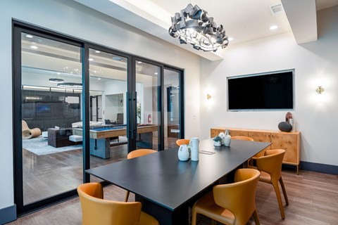A modern dining room with a black table and yellow chairs.