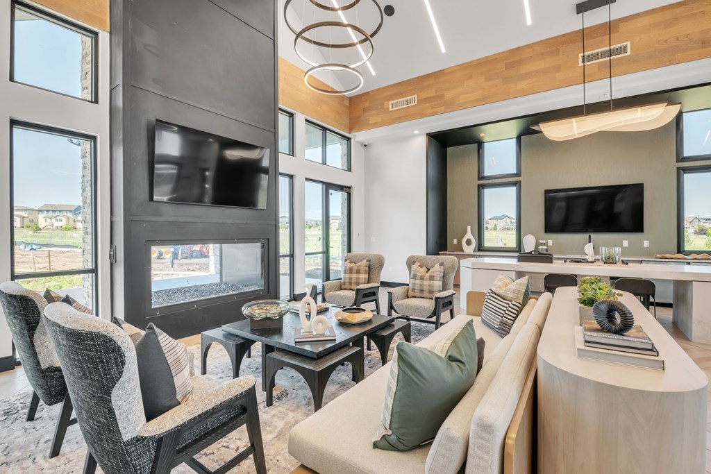 A modern living room with a large couch, a coffee table, and a flat-screen TV.