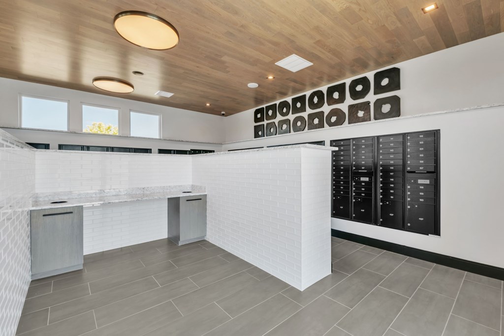 A modern kitchen with a white counter and black cabinets.