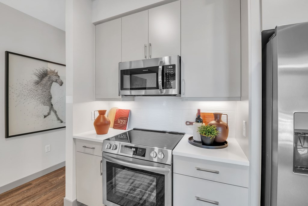 A modern kitchen with a stove top oven and microwave above it.