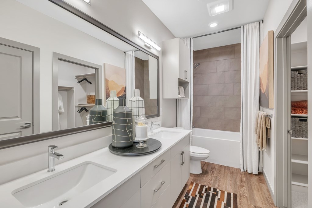 A modern bathroom with a white sink and a large mirror.