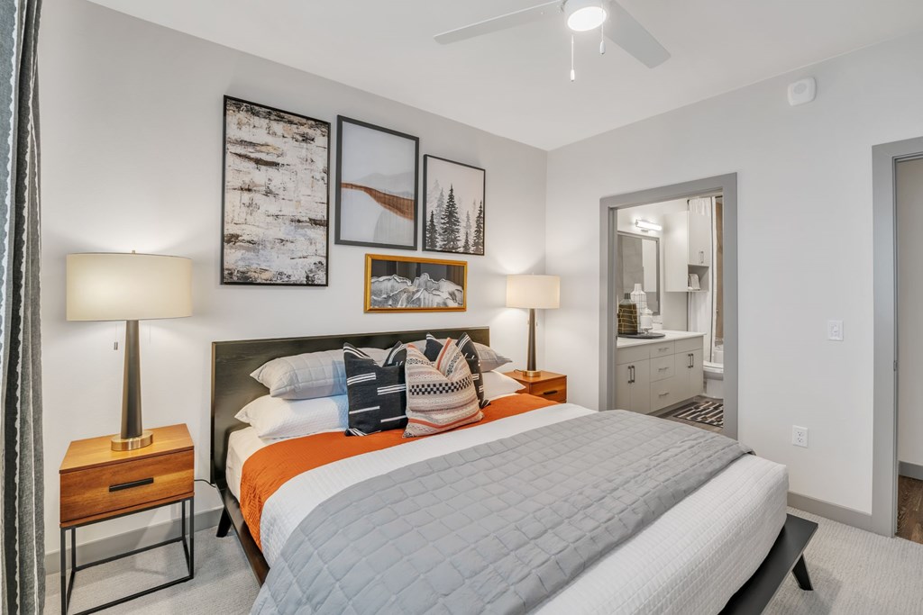 A bedroom with a large bed and a ceiling fan.