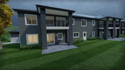 A modern apartment complex with a grassy front yard.