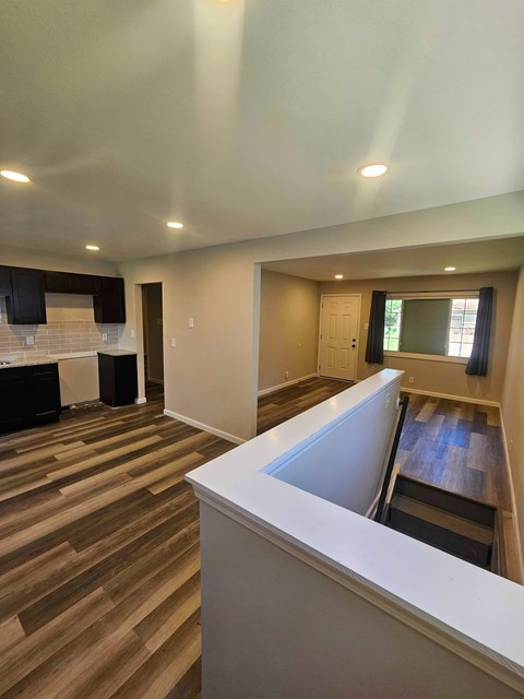 A room with a white counter and wooden floors.