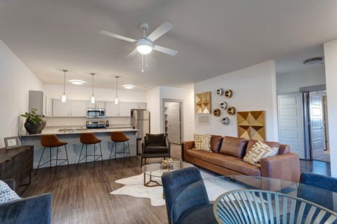 A modern living room with a bar area and a kitchen in the background.