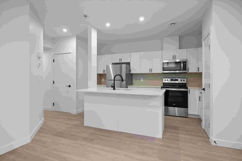 A kitchen with white cabinets and appliances.