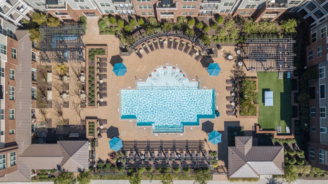 an aerial view of a pool in the middle of an apartment complex