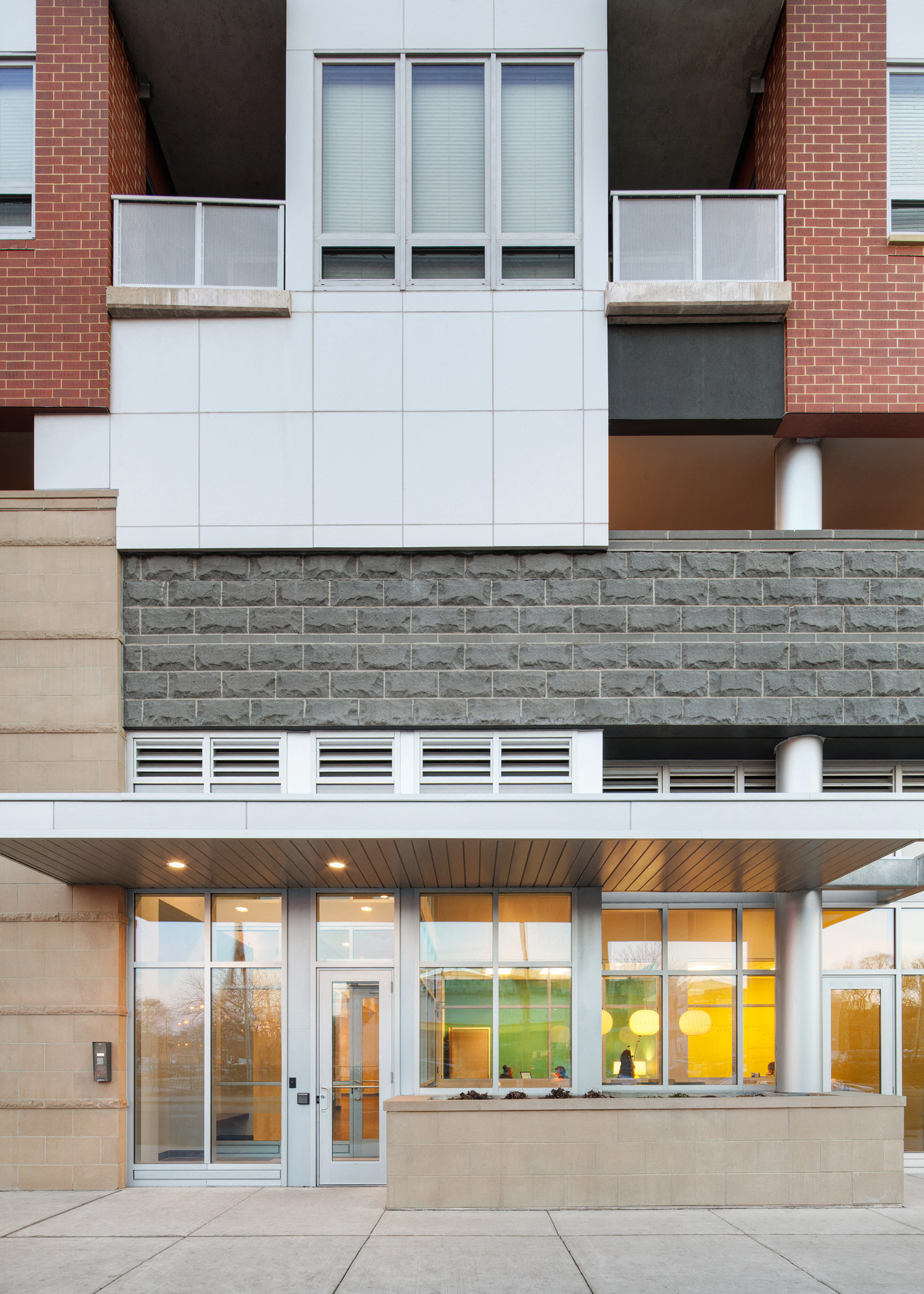 the entrance of a building with glass doors and a brick facade