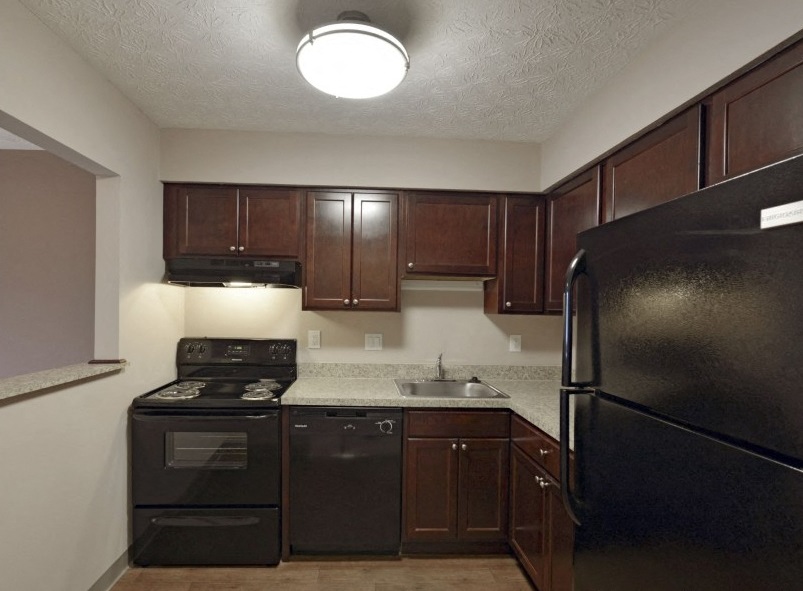 a kitchen with black appliances and a black refrigerator