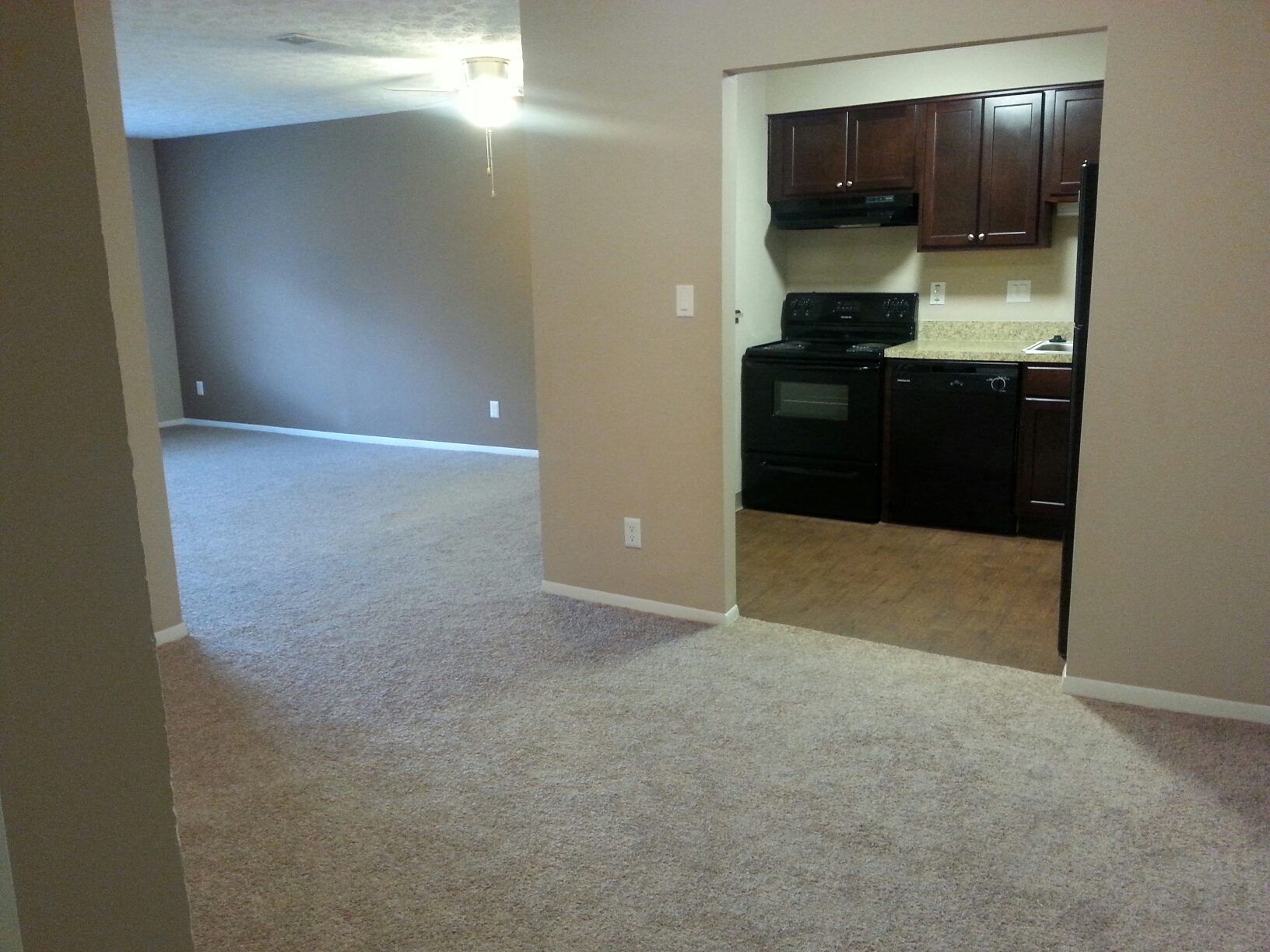 an empty living room with a kitchen in it
