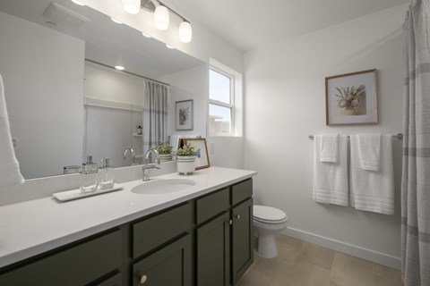 A bathroom with a white countertop and green cabinets.