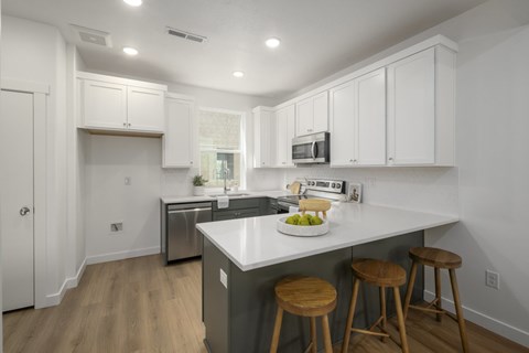 A kitchen with white cabinets and a white counter top.