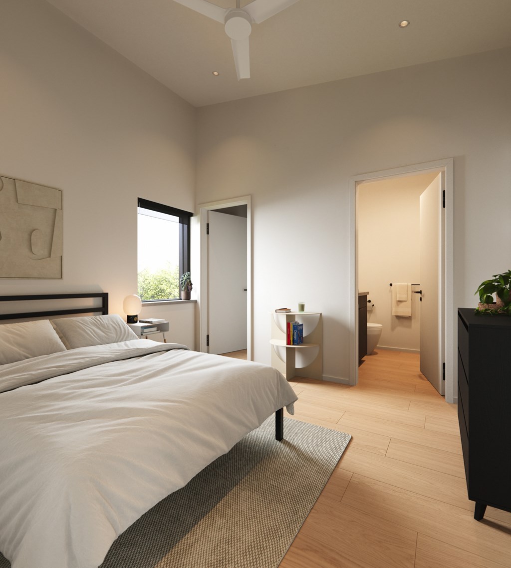 A bedroom with a large bed and a ceiling fan.