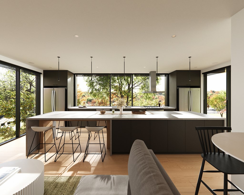 A modern kitchen with a large island and chairs.
