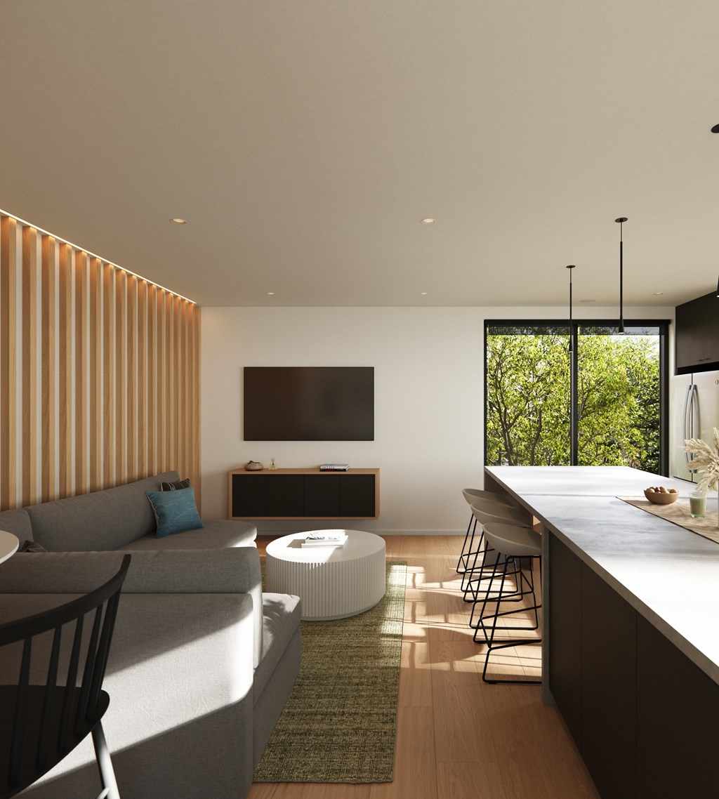 A modern living room with a grey sofa and a television on a wooden cabinet.