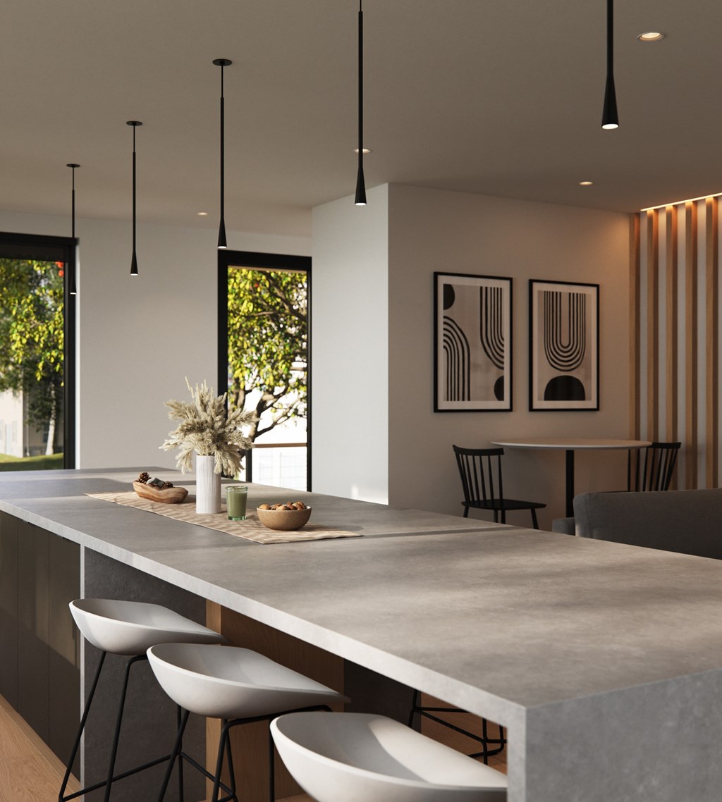 A modern kitchen with a long counter and bar stools.