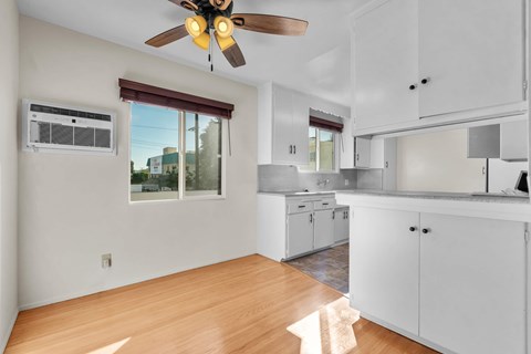 A kitchen with white cabinets and a ceiling fan.