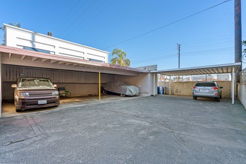 A parking lot with two cars and a building in the background.