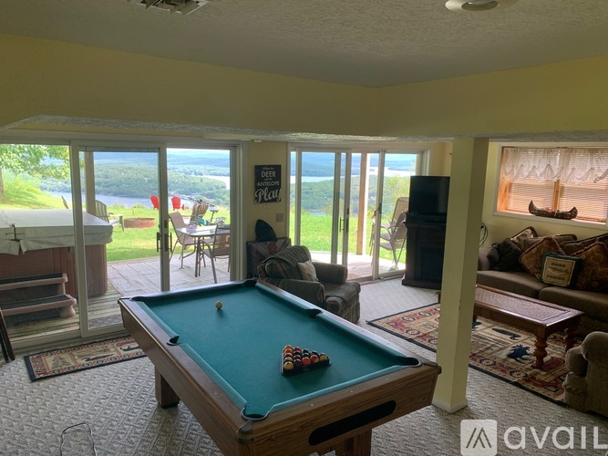 A pool table in a room with sliding glass doors.