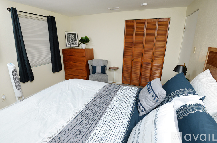 A bedroom with a large bed and a wooden headboard.