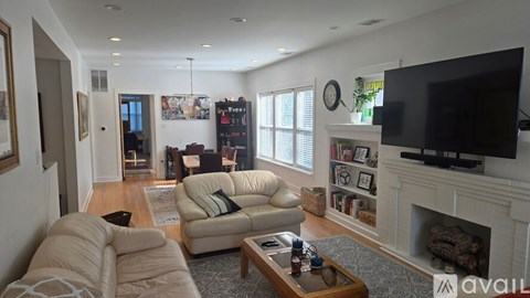 A living room with a fireplace and a television on the wall.