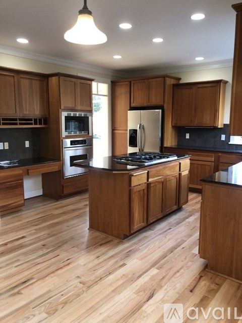 A kitchen with wooden cabinets and a black countertop.